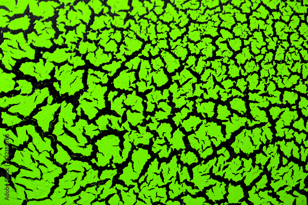 The cracked surface of green paint on a black background, the effect of craquelure paint. Green texture of antique design in bright color. The cracked surface of green paint on a black background, the effect of craquelure paint. Green texture of antique design in bright color.
