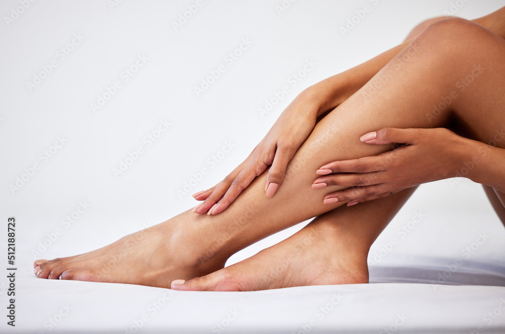 These legs wont moisturise themselves. Cropped shot of an unrecognisable woman touching her legs while sitting against a white background. These legs wont moisturise themselves. Cropped shot of an unrecognisable woman touching her legs while sitting against a white background.