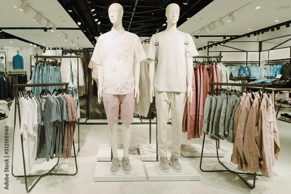 Two mannequins in empty modern fashionable mass market clothing store inside shopping center