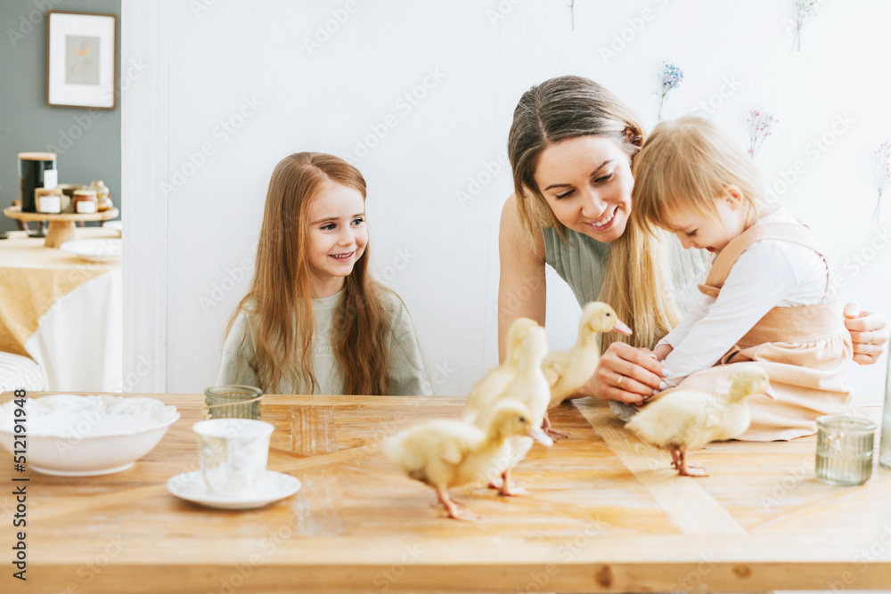 Φωτογραφία two cute little red haired girls sisters and mother young woman stand in kitchen