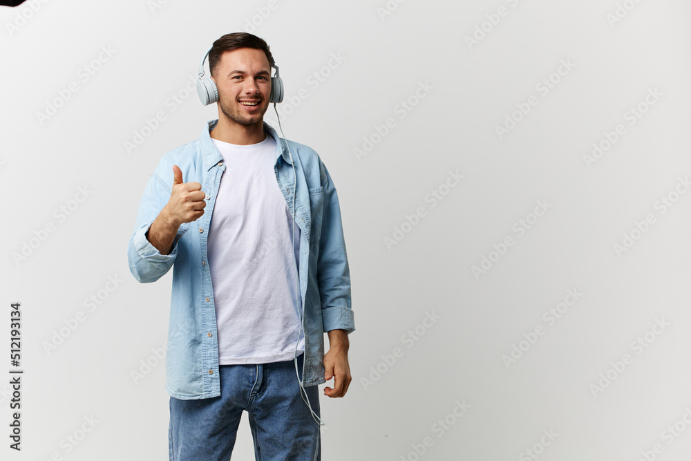 Happy smiling tanned handsome man in casual basic t-shirt headphones show thumb up gesture Like posing isolated on over white studio background. Copy space Banner Mockup. Cool playlist concept Happy smiling tanned handsome man in casual basic t-shirt headphones show thumb up gesture Like posing isolated on over white studio background. Copy space Banner Mockup. Cool playlist concept
