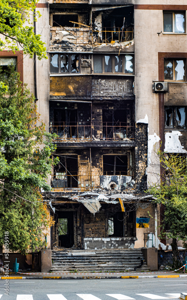 Bucha, Ukraine - May 22, 2022: Russia's aggression against Ukraine. Facade of the building and stairs after tank shots. Destroyed building. Stairs of an abandoned house. House exterior Bucha, Ukraine - May 22, 2022: Russia's aggression against Ukraine. Facade of the building and stairs after tank shots. Destroyed building. Stairs of an abandoned house. House exterior