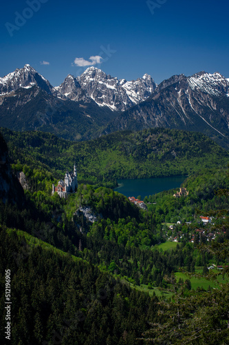 Alpine mountain view in the morning light on a sunny day in summer at Neuschwanstein Castle and the Alpsee lake in Allgau, Germany with a view of the Allgau Alps