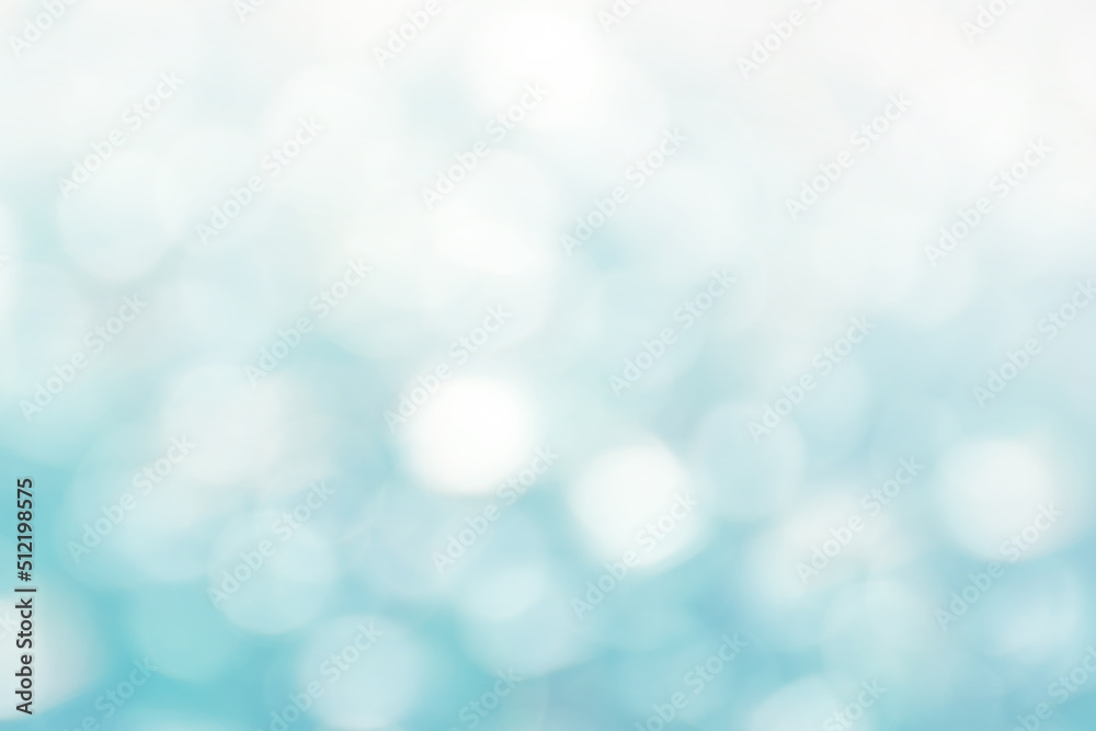 Defocused Bright abstract winter blue background with white shimmering sunspots. Bokeh. Holiday festive concept. Copy space for text. Merry Christmas and Happy New Year