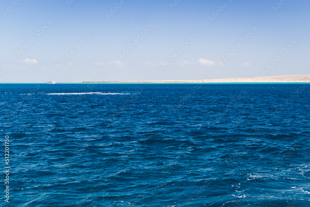 Obraz premium Beautiful seascape near Hurgada, Coast in Egypt Red Sea. Amazing nature background Luxury holiday resort. Boat on the horizon among the blue sea surface