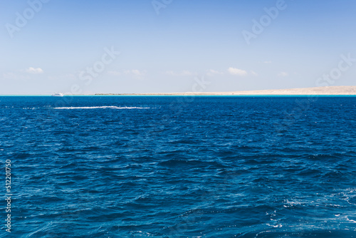 Fototapeta Naklejka Na Ścianę i Meble -  Beautiful seascape near Hurgada, Coast in Egypt Red Sea. Amazing nature background Luxury holiday resort. Boat on the horizon among the blue sea surface