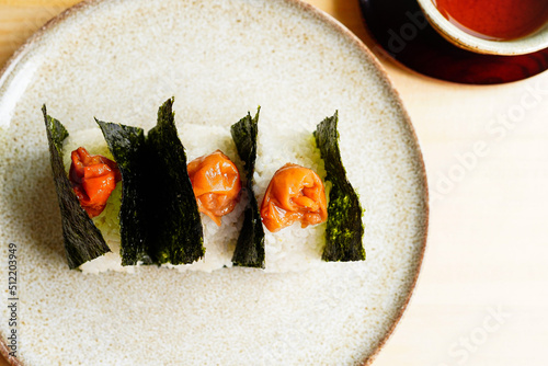 High-angle shot of Onigiri wrapped in nori with umeboshi on top 