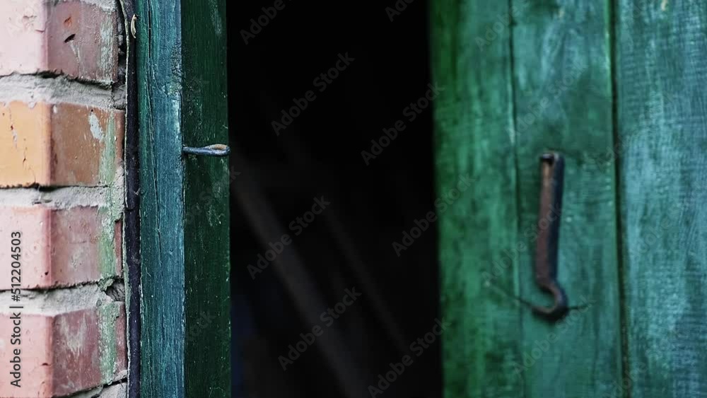 Caucasian man's hand opens a wooden door in a house locked on a hook. Caucasian man's hand opens a wooden door in a house locked on a hook.