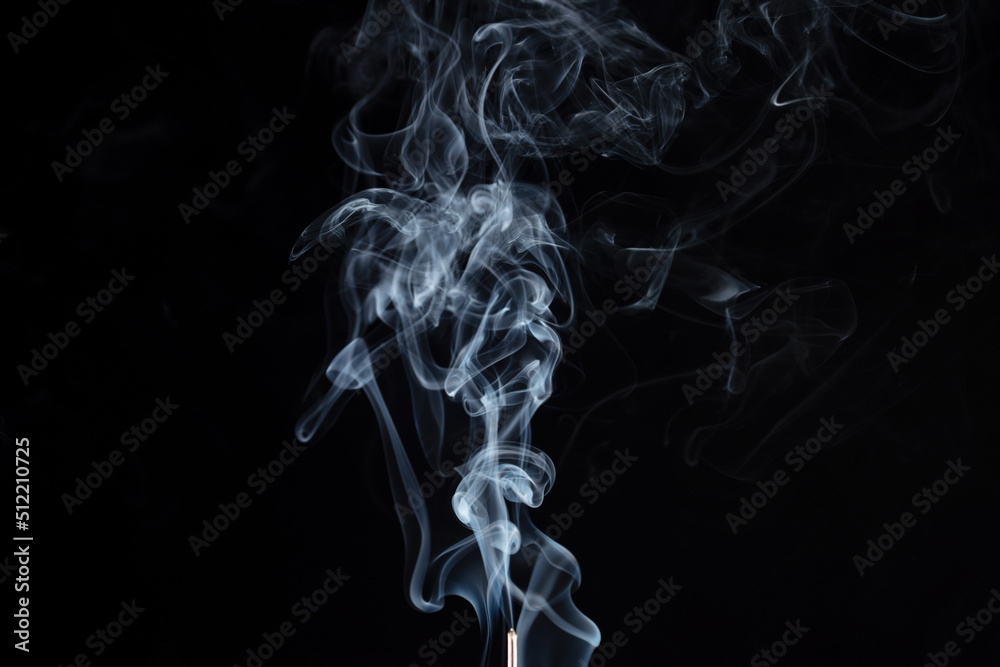 incense stick with smoke against black background incense stick with smoke against black background