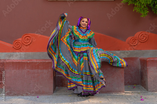 Young Mexican woman in a traditional folklore dress of many colors, traditional dancer.