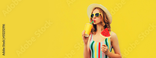 Summer colorful portrait of beautiful young woman drinking juice with lollipop or ice cream shaped slice of watermelon wearing straw hat on yellow background, blank copy space for advertising text