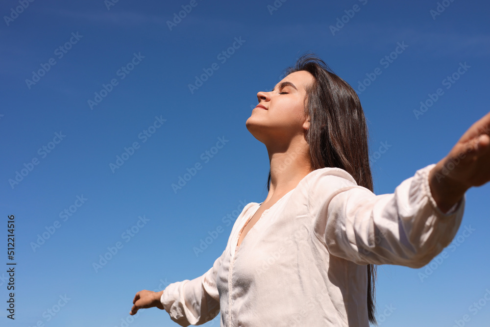 Portrait of beautiful young woman against blue sky. Space for text Portrait of beautiful young woman against blue sky. Space for text