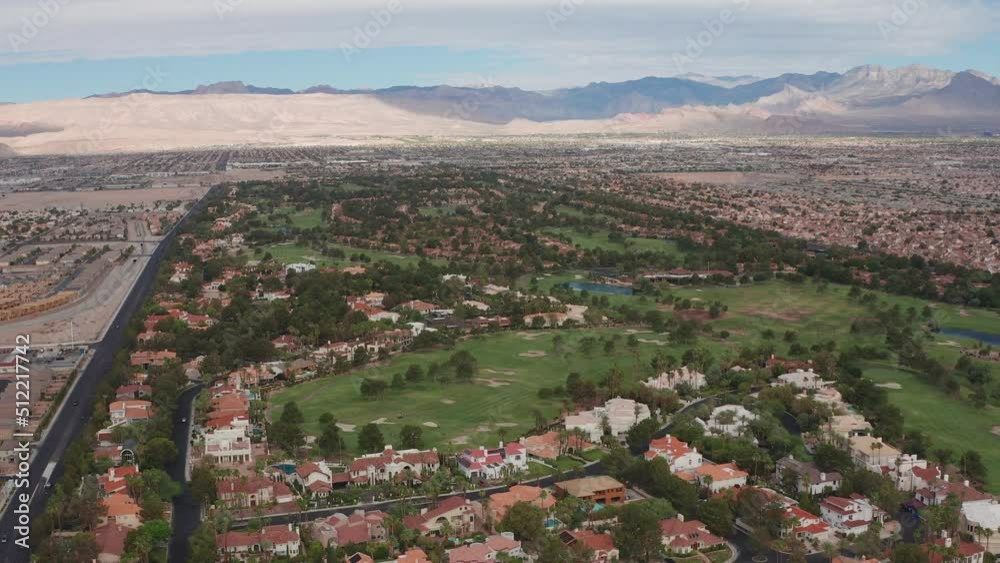 Aerial view of Las Vegas residential community with golf course and mountains Aerial view of Las Vegas residential community with golf course and mountains