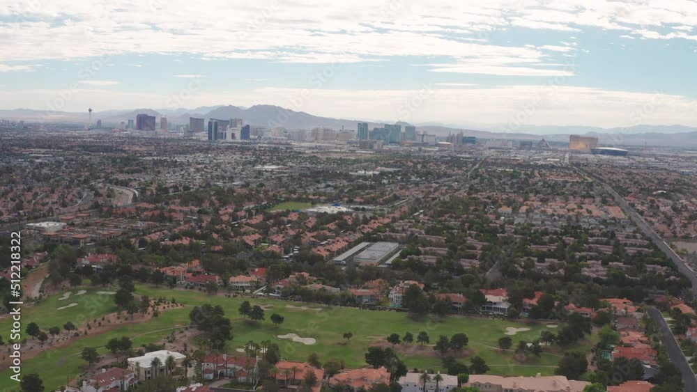 Aerial pullback view of gated Las Vegas community with city skyline strip view Aerial pullback view of gated Las Vegas community with city skyline strip view