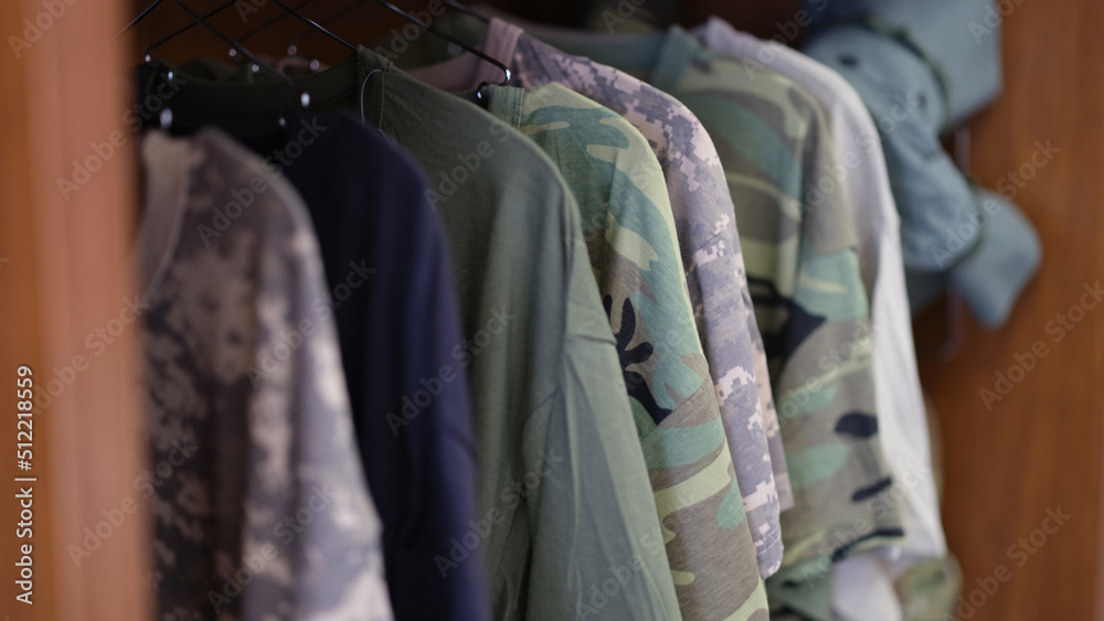 Fototapeta premium Collection of military uniform tshirts in wardrobe