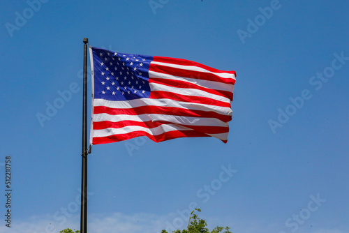 US flag on a blue sky blowing in the wind