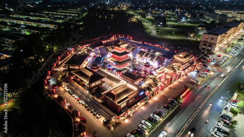 Fototapeta Naklejka Na Ścianę i Meble -  Aerial view of Shanghai old town street decorated with red chinese lanterns at night. Street market in Kelapa Gading, Chinese lanterns on the houses, Jakarta, Indonesia, June 21, 2022