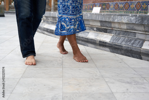 Bare feet of a transgender couple walking outside a Buddhist temple