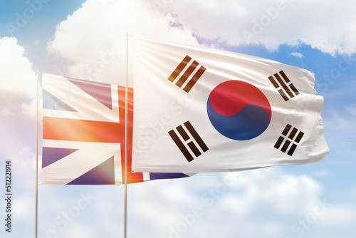 Sunny blue sky and flags of south korea and great britain