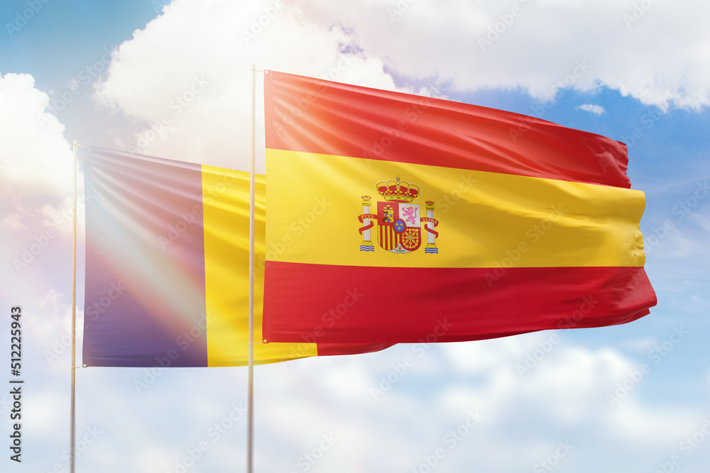 Fototapeta premium Sunny blue sky and flags of spain and romania