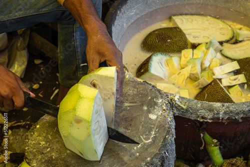 man chopping fresh organic unripe jack fruit for vegetable from farm close up shot