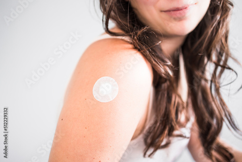 Canvas-taulu woman showing covid-19 or flu vaccination band-aid on her arm, protection from t