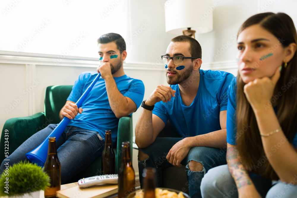 Obraz premium Worried sports fans watching the soccer championship together on tv