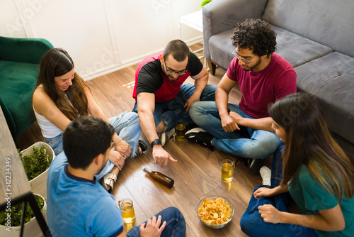 Friends having fun while playing a spin the bottle game