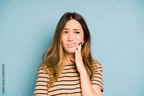 Sad Caucasian woman with a toothache looking sad in a studio photo