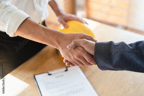 close up view hands of agent and client shaking hands after signed contract buy new apartment.