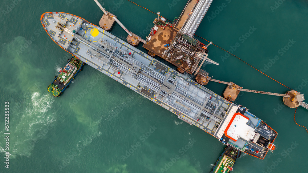 Aerial top view oil tanker ship at oil terminal industrial port tugboat ...