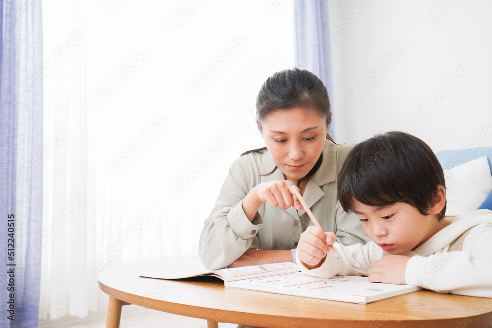 家でお母さんと一緒に勉強をする男の子 家でお母さんと一緒に勉強をする男の子