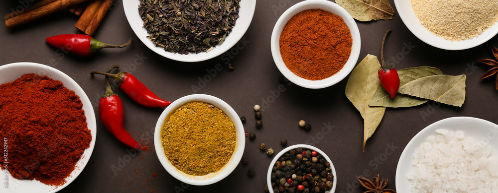 Composition with aromatic spices and herbs on dark background, top view