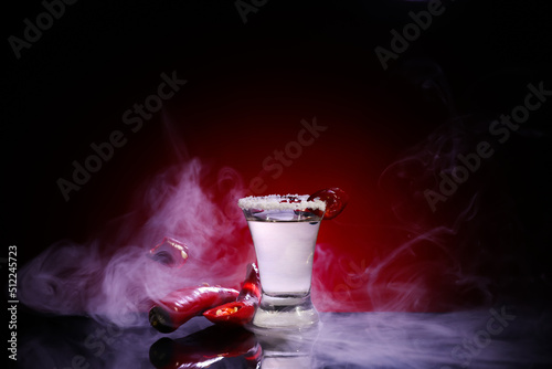 Shot of tasty mexican tequila with chili pepper on color background