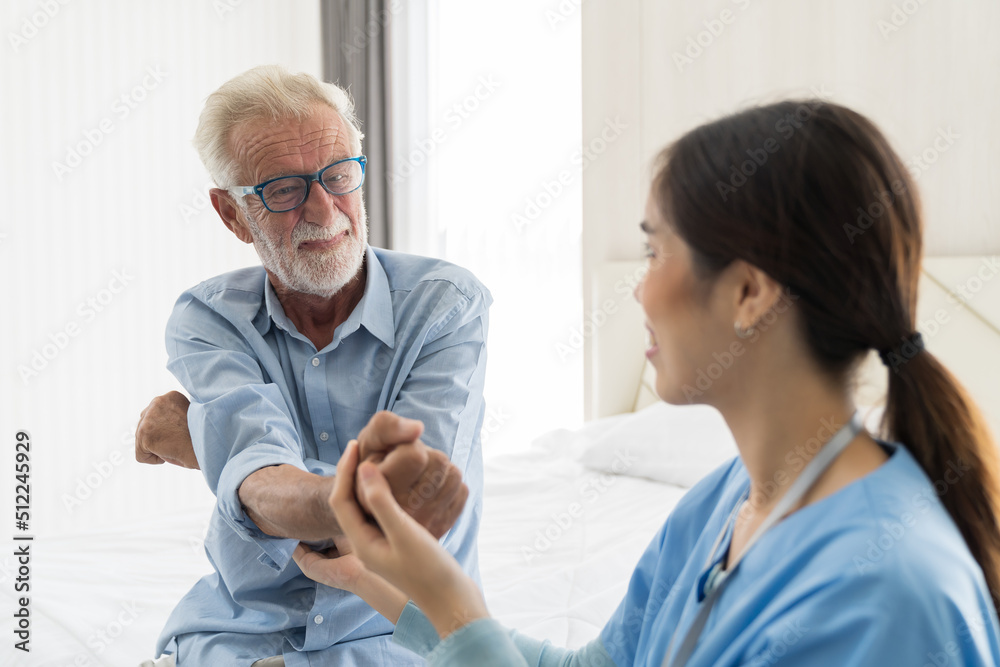 Obraz premium Female nurse physical therapy elderly man at hospital ward. Asian female nurse caring elderly man patient. Hospital care and older adults concept