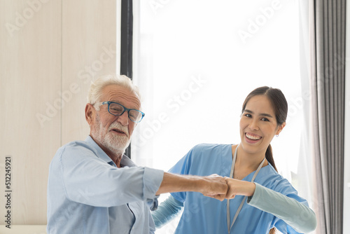 Female nurse physical therapy elderly man at hospital ward. Asian female nurse caring elderly man patient. Hospital care and older adults concept