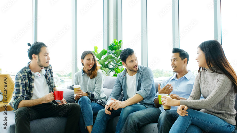 Obraz premium Group of happy creative team talking while taking coffee break at office