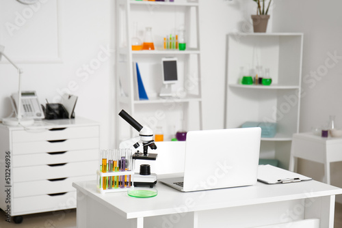 Modern workplace, microscope, chemical glassware and laptop in medical laboratory © Pixel-Shot