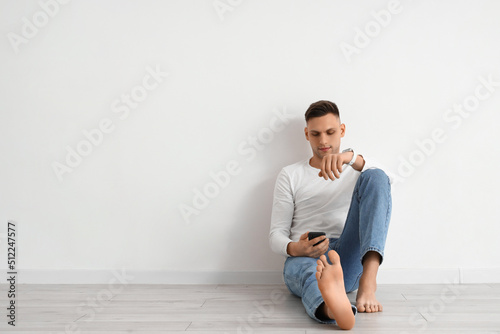 Young barefoot man using mo...