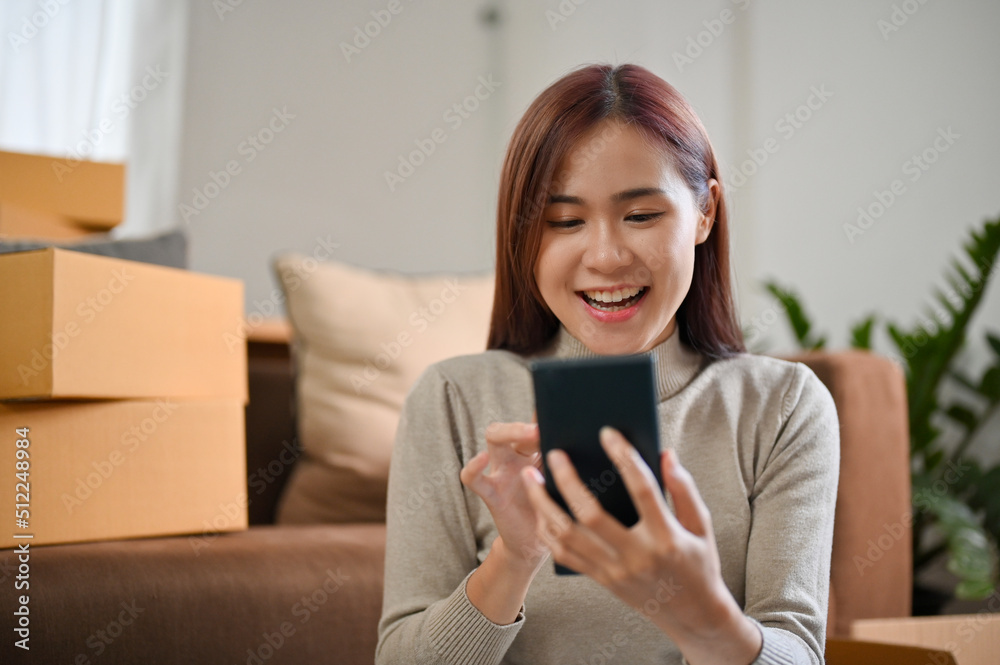 Female SME entrepreneur replying a customer question via her smartphone Female SME entrepreneur replying a customer question via her smartphone
