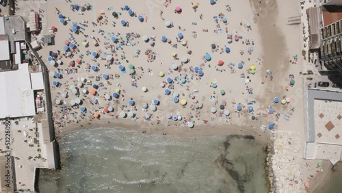 Aerial overhead static hyperlapse of beach goers enjoying the sea in Bari, Italy. photo