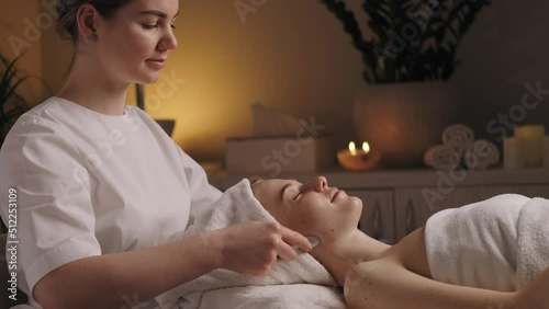 Woman during a massage on the neckline with professional tools at these salon. Dermatology skin care facial therapy. Medical spa anto wrinkles procedure. Woman photo