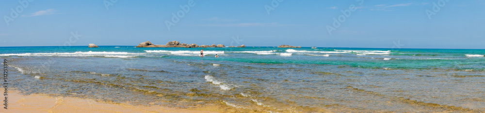 Hikkaduwa, Sri Lanka - March 8, 2022: Panoramic view of the Indian Ocean with azure water at low tide near the coral reef of Hikkaduwa beach. Copy space