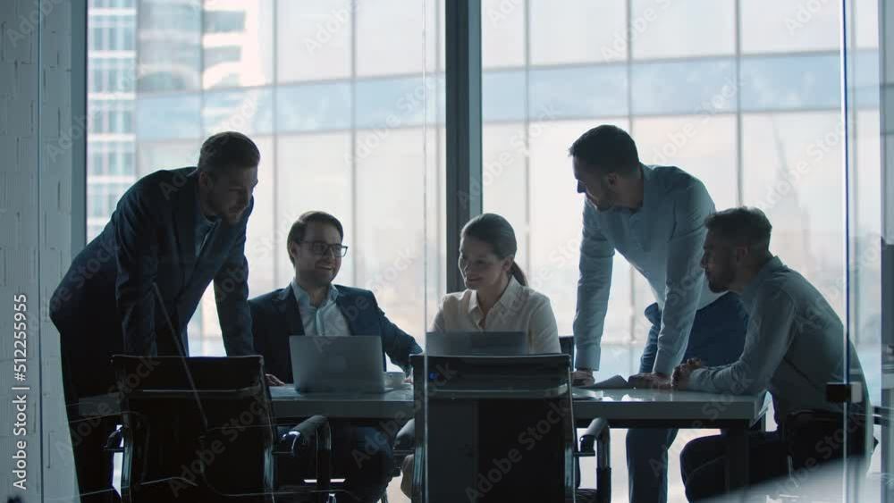Group of business people working at a table at meeting room. Mature business people working with laptop Group of business people working at a table at meeting room. Mature business people working with laptop