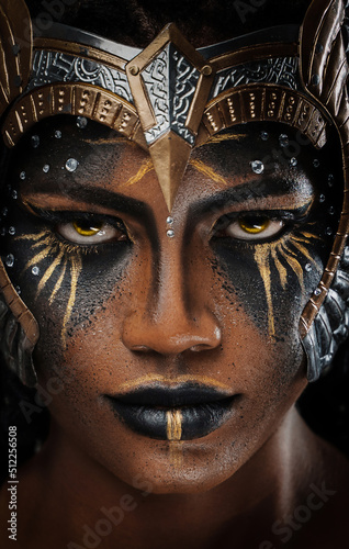 Studio shot of ancient black woman amazon staring at camera against grey background.