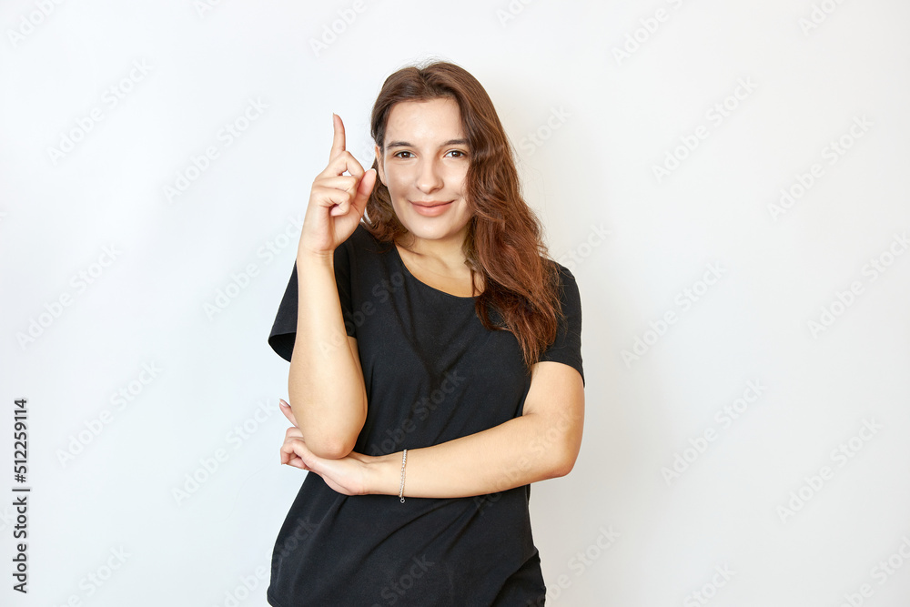 Pretty girl holding raised hand with index finger. The concept of attention and caution.