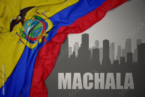 abstract silhouette of the city with text Machala near waving national flag of ecuador on a gray background. photo