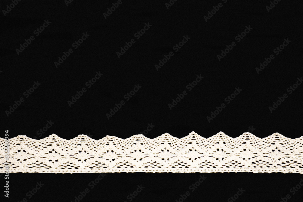 White lace in shape of ribbon on black background isolated. Sewing concept - obrazy, fototapety, plakaty 