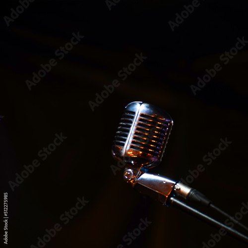 Shiny retro microphone on a black background. Soft focus