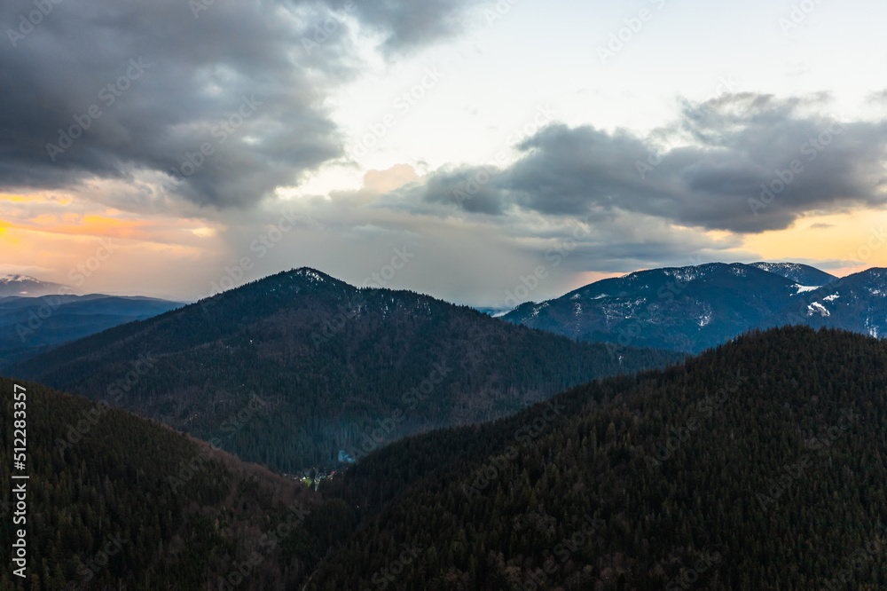 Panorama of the Carpathians in the Synevyrska Polyana Natural Park, forest with snow and morning fog and clouds, clouds at the foot of the mountains.